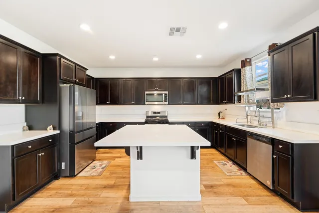 a kitchen with stainless steel appliances a stove refrigerator sink and microwave