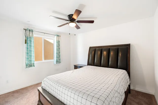 a spacious bedroom with a bed and a ceiling fan
