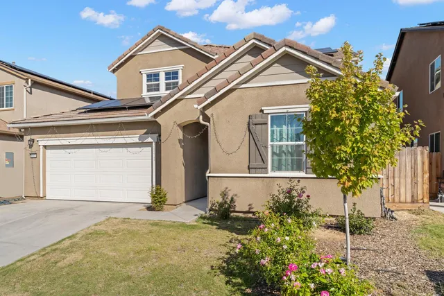 a view of a house with a small yard and potted plants