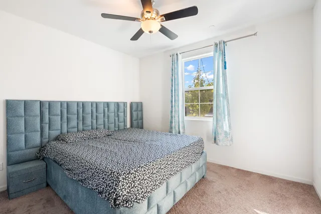 a spacious bedroom with a bed and a ceiling fan
