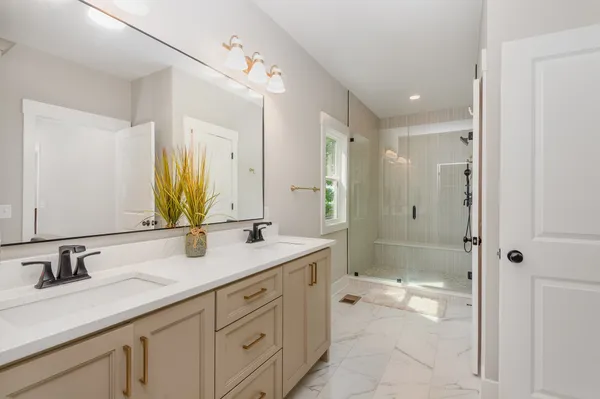 a spacious bathroom with a shower sink double and mirror