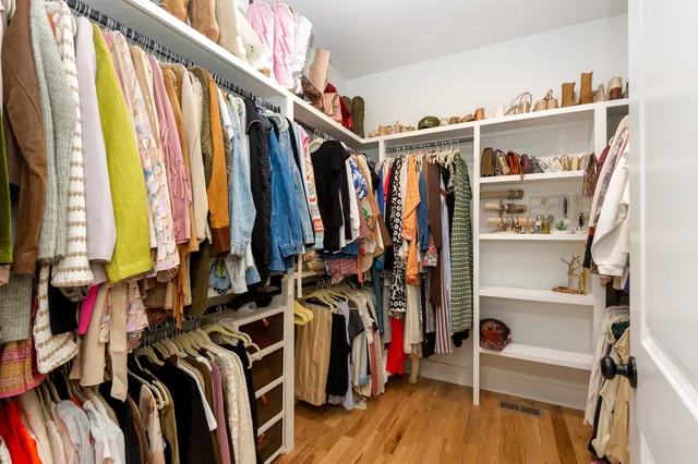 a view of walk in closet with clothes and shoes
