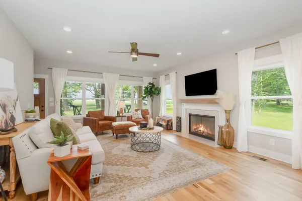 a living room with furniture a fireplace and a flat screen tv