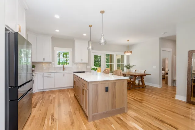 a kitchen with a sink stove and wooden floor