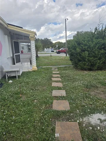 a pathway of a house with a yard