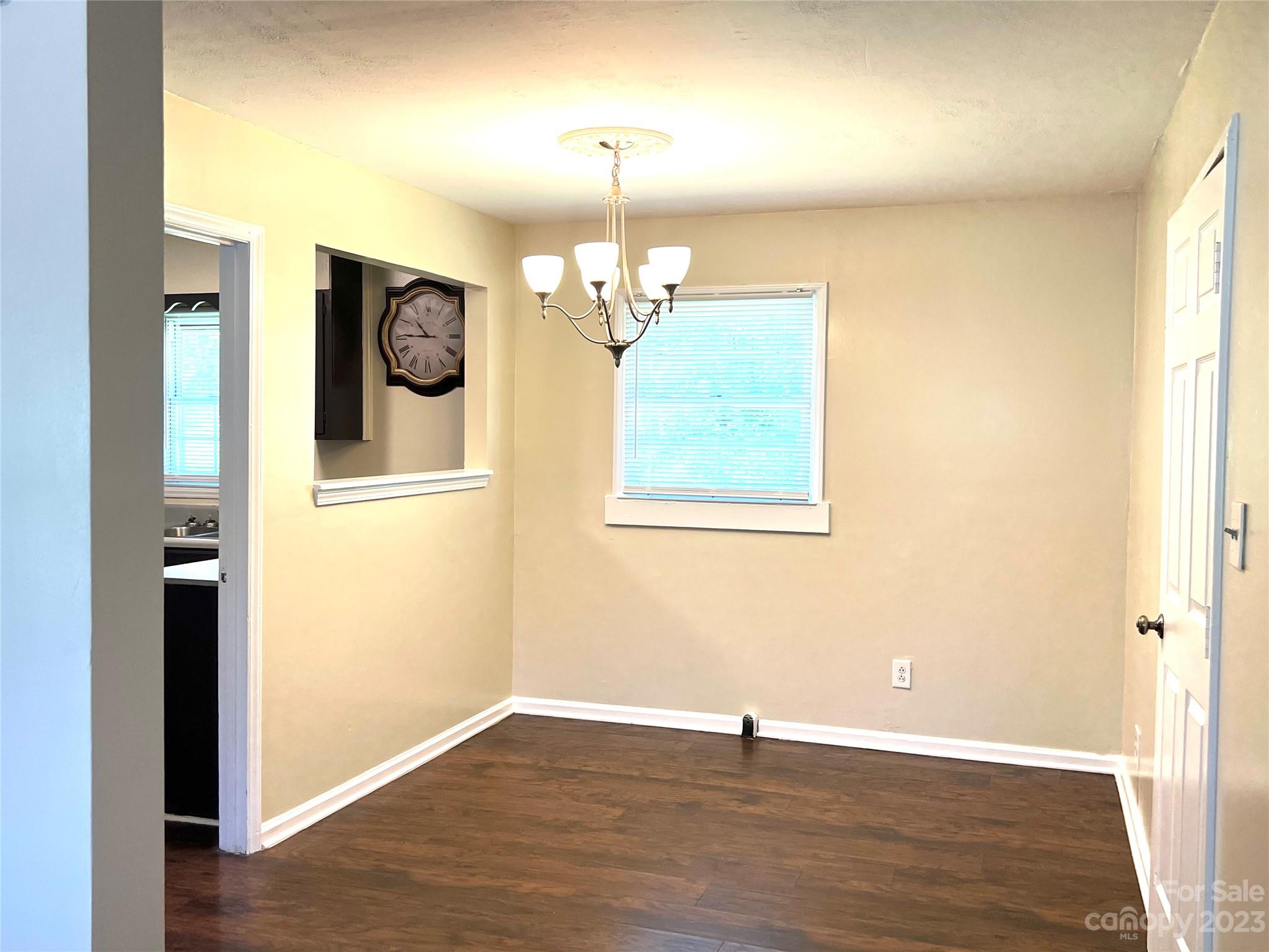 911 Taylor Street Wingate, NC 28174 - Photo 8 of 12 an empty room with wooden floor mirror and windows