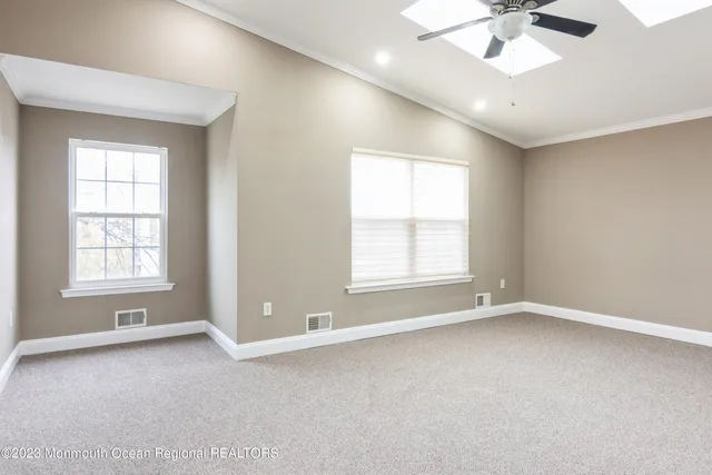 an empty room with windows and ceiling fan