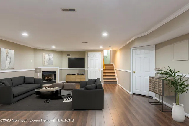a living room with furniture a wooden floor and a fireplace