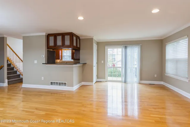 a view of a living room with wooden floor and a window