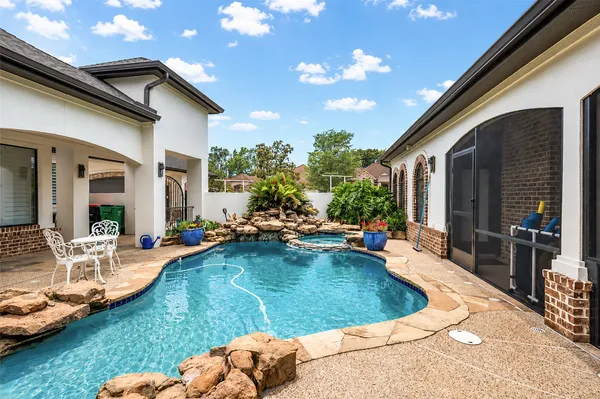 a view of swimming pool with lawn chairs and couches