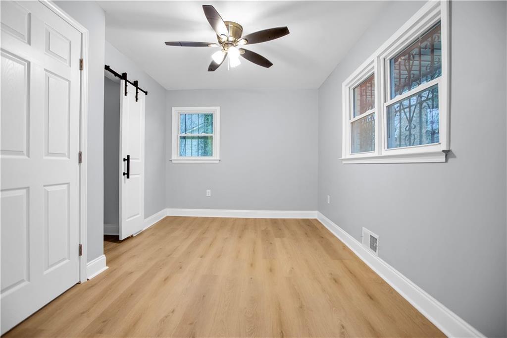 2000 Fairburn Road Southwest Atlanta, GA 30331 - Photo 19 of 24 an empty room with wooden floor chandelier fan and windows