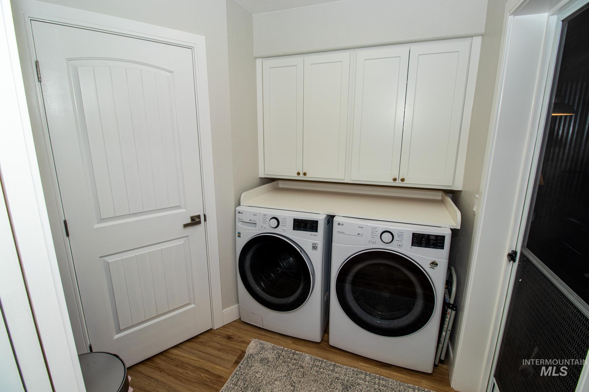 5404 Freeman Creek Road Lenore, ID 83541 - Photo 14 of 50 Laundry area featuring dark wood finished floors, cabinet space, and washing machine and clothes dryer