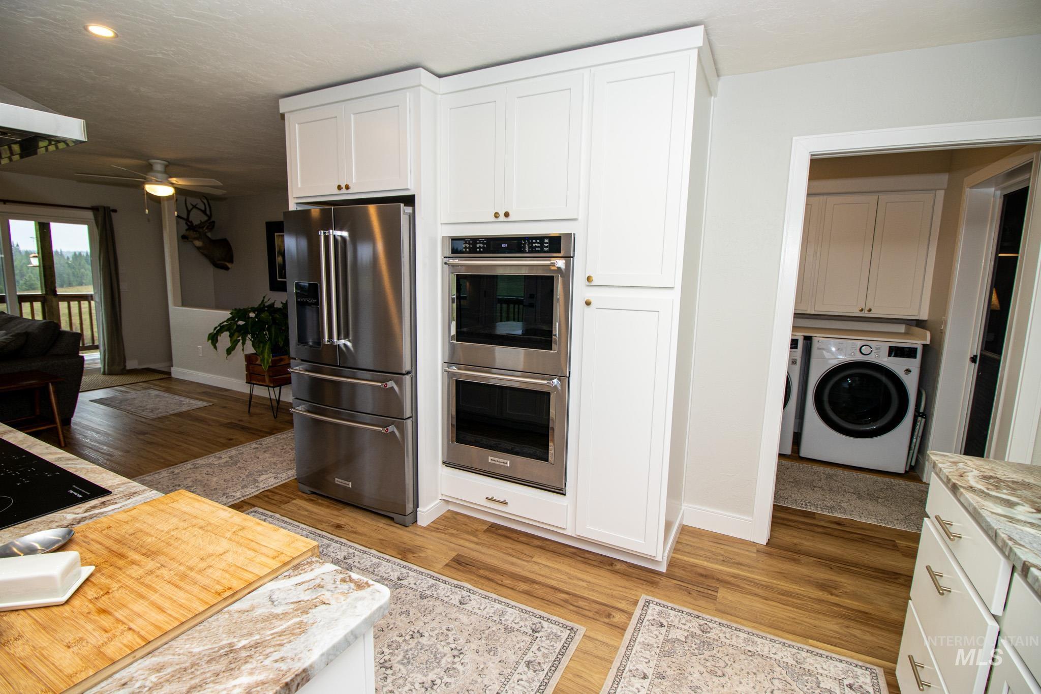 5404 Freeman Creek Road Lenore, ID 83541 - Photo 21 of 50 Kitchen featuring stainless steel appliances, a ceiling fan, light wood finished floors, and white cabinets