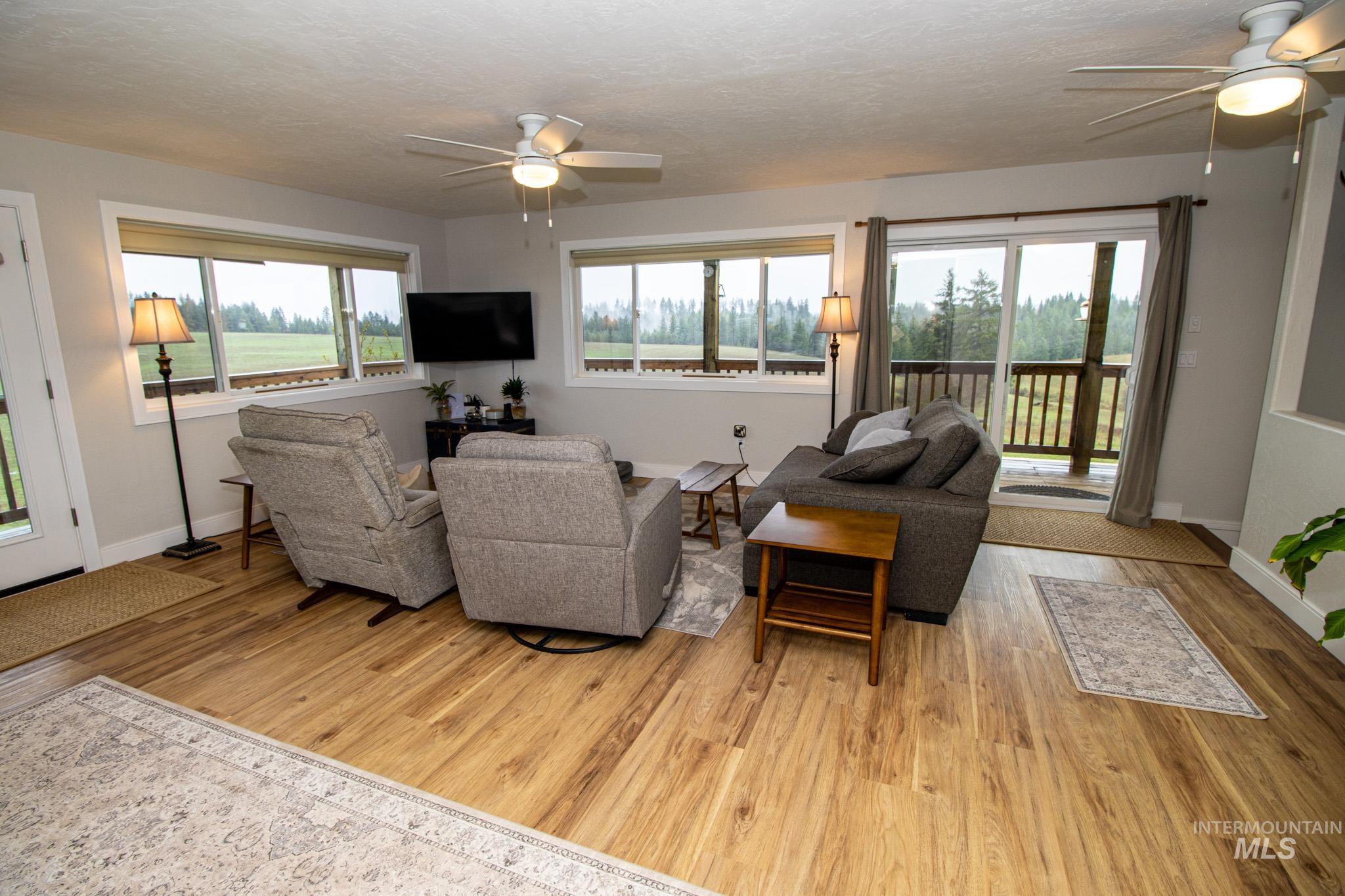 5404 Freeman Creek Road Lenore, ID 83541 - Photo 24 of 50 Living room featuring a ceiling fan, light wood finished floors, and a textured ceiling