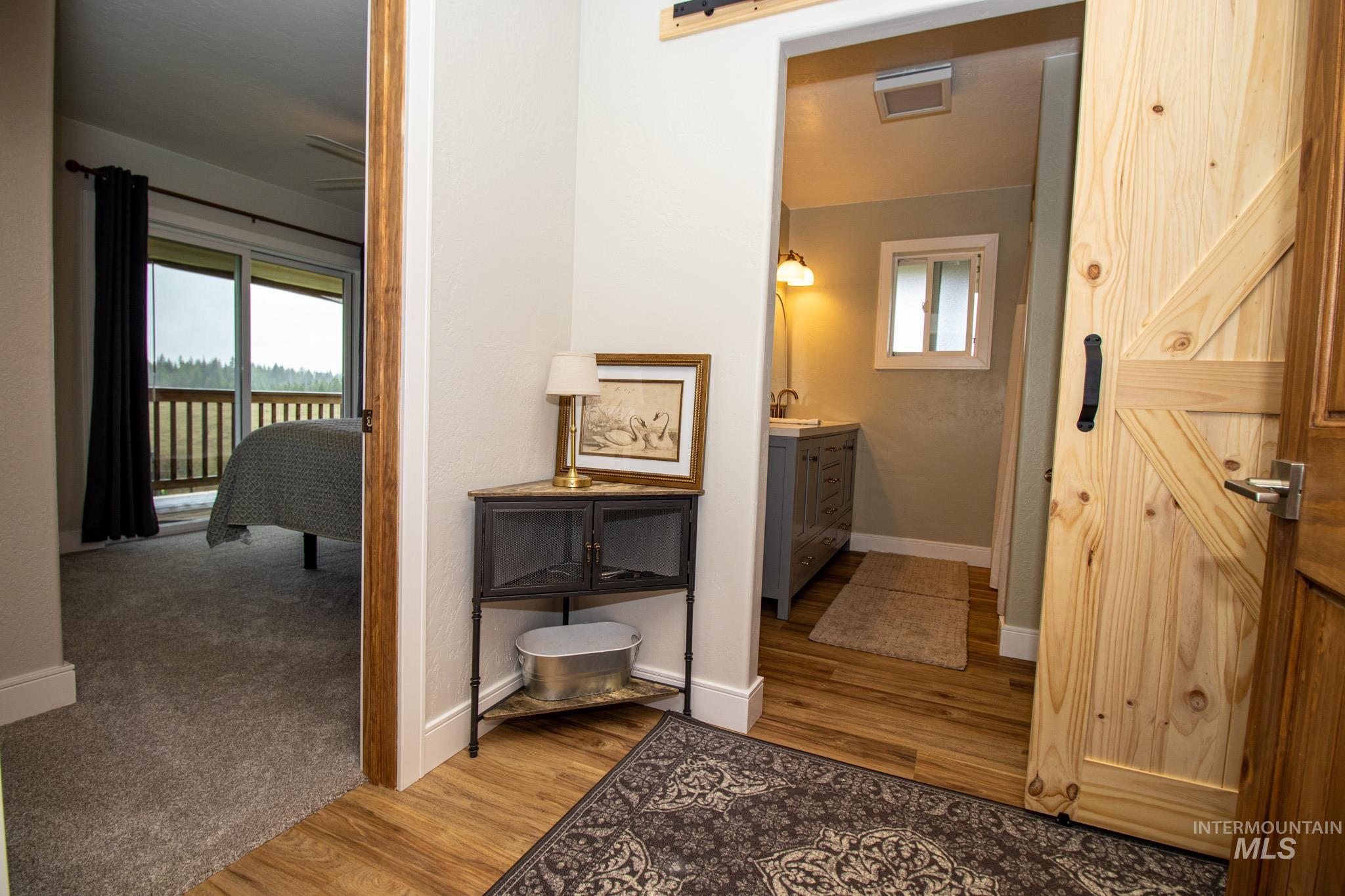 5404 Freeman Creek Road Lenore, ID 83541 - Photo 28 of 50 Corridor featuring light wood finished floors, a barn door, and healthy amount of natural light