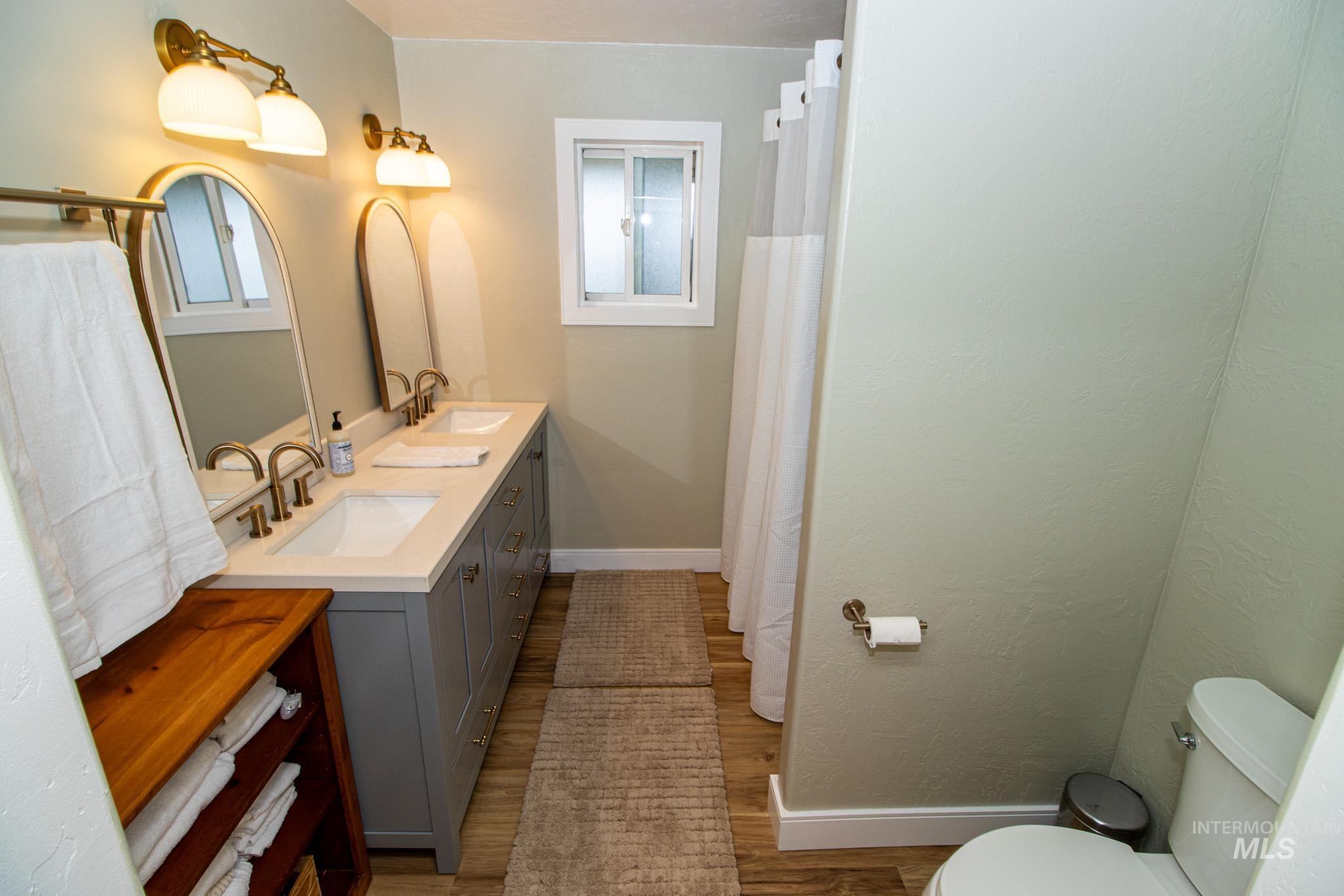 5404 Freeman Creek Road Lenore, ID 83541 - Photo 30 of 50 Full bath with double vanity, a shower with shower curtain, and light wood-style floors