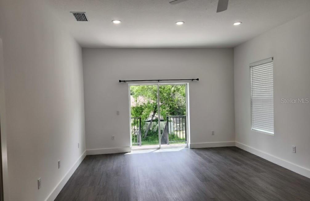 9211 Northcliffe Boulevard Spring Hill, FL 34606 - Photo 13 of 30 an empty room with wooden floor and windows