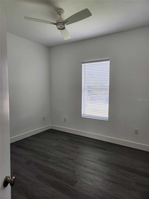 9211 Northcliffe Boulevard Spring Hill, FL 34606 - Photo 20 of 30 a view of an empty room with wooden floor and a window