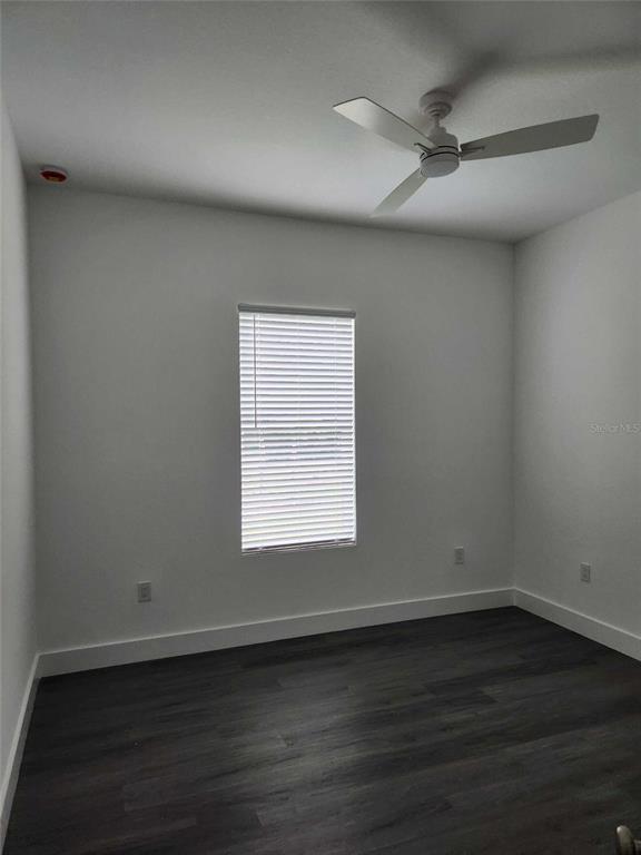 9211 Northcliffe Boulevard Spring Hill, FL 34606 - Photo 25 of 30 an empty room with wooden floor fan and windows