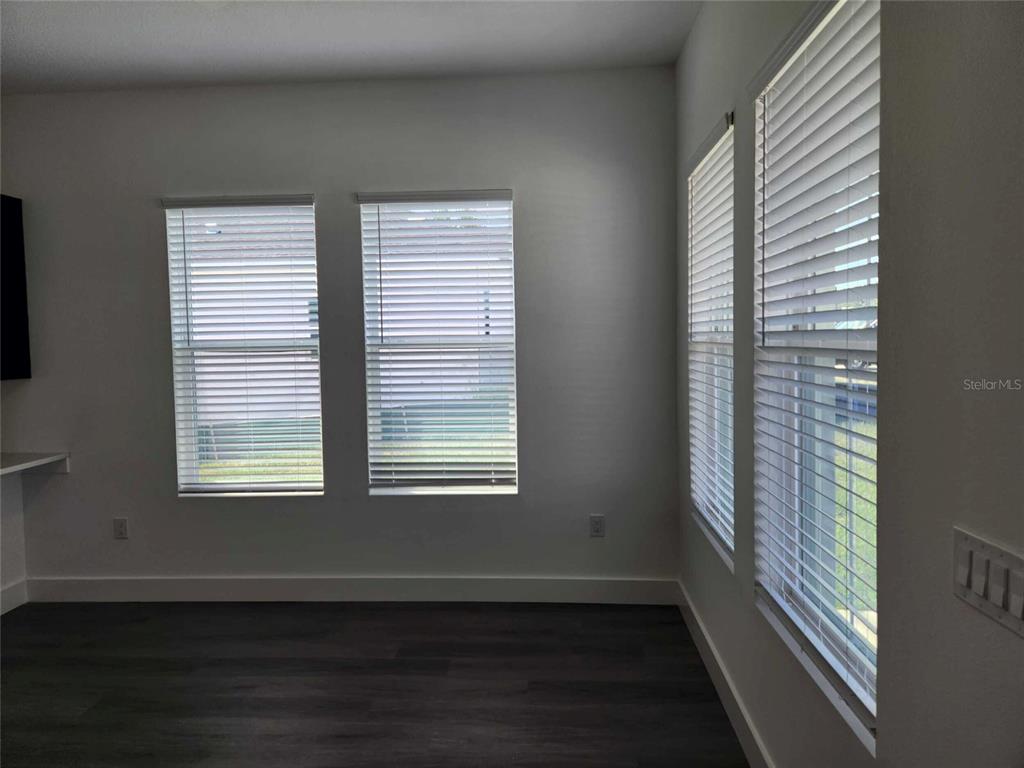 9211 Northcliffe Boulevard Spring Hill, FL 34606 - Photo 5 of 30 a view of an empty room with wooden floor and a window