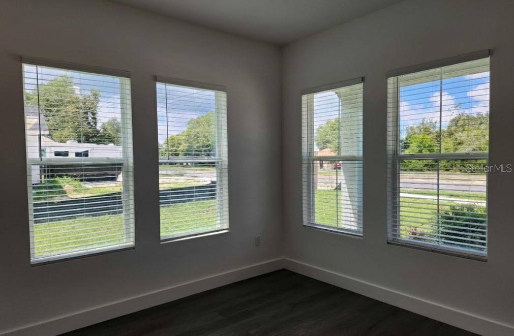 9211 Northcliffe Boulevard Spring Hill, FL 34606 - Photo 6 of 30 a view of an empty room with wooden floor and a window