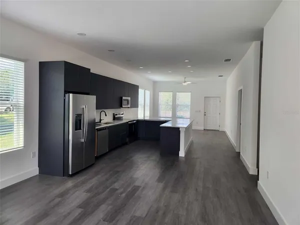 a kitchen with stainless steel appliances a sink a refrigerator and wooden cabinets