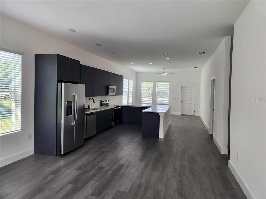 9211 Northcliffe Boulevard Spring Hill, FL 34606 - Photo 9 of 30 a kitchen with a refrigerator and a sink
