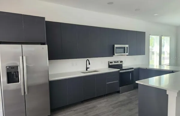 a view of a kitchen with a sink and wooden floor