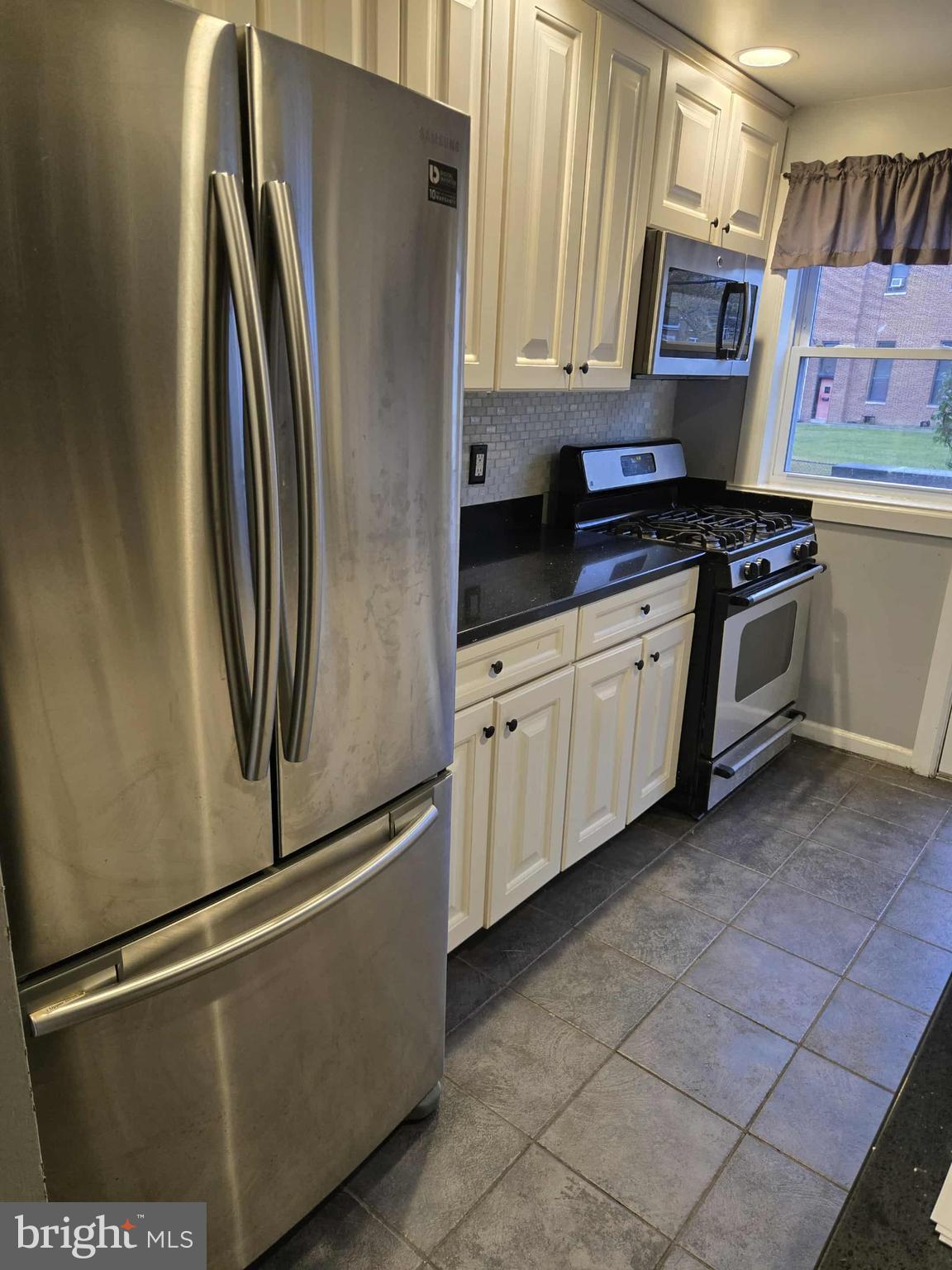4408 Shamrock Avenue Baltimore, MD 21206 - Photo 3 of 18 a kitchen with stainless steel appliances granite countertop a refrigerator a stove a sink and a microwave