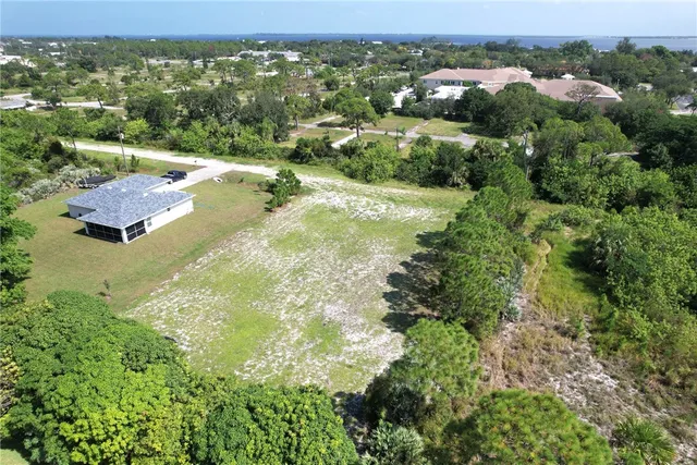 an aerial view of residential houses with outdoor space and trees