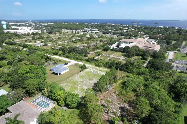 an aerial view of residential houses with outdoor space and trees