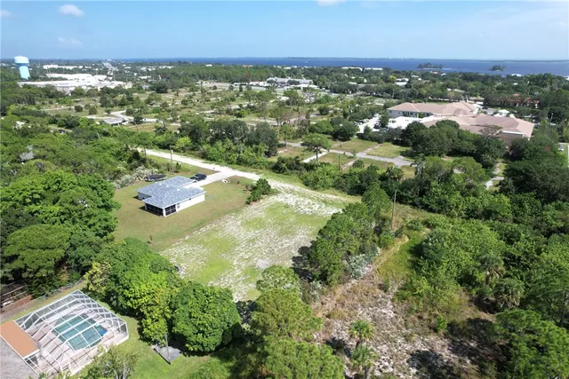 an aerial view of residential houses with outdoor space and trees