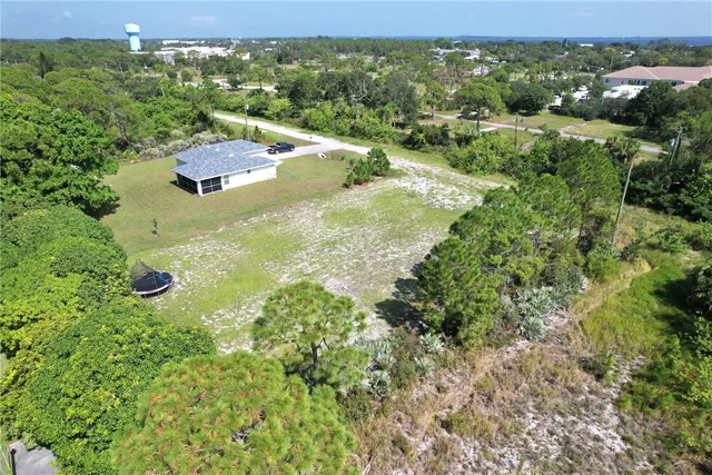 an aerial view of residential houses with outdoor space and trees