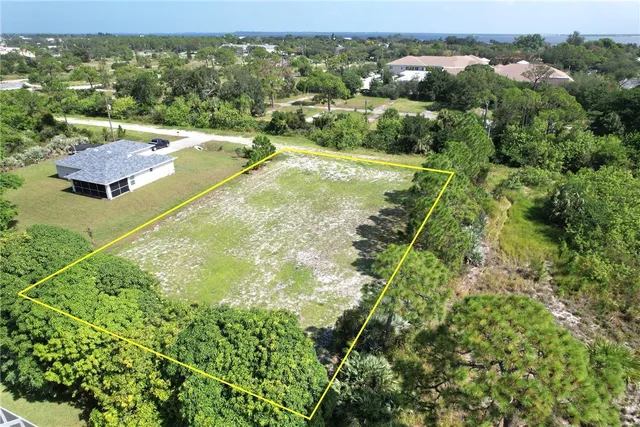 an aerial view of residential houses with outdoor space and trees