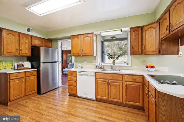 a kitchen with stainless steel appliances granite countertop a refrigerator stove top oven and sink