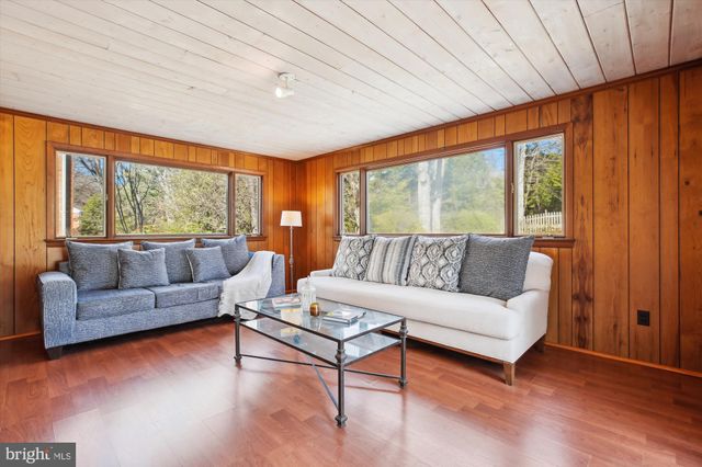 a living room with furniture a large window and wooden floor