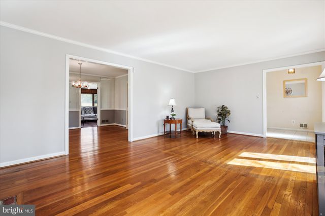 a living room with wooden floor and a table