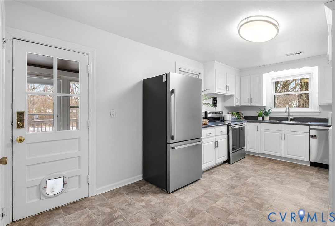 609 Woodstock Road Richmond, VA 23224 - Photo 11 of 33 a kitchen with white cabinets and white appliances