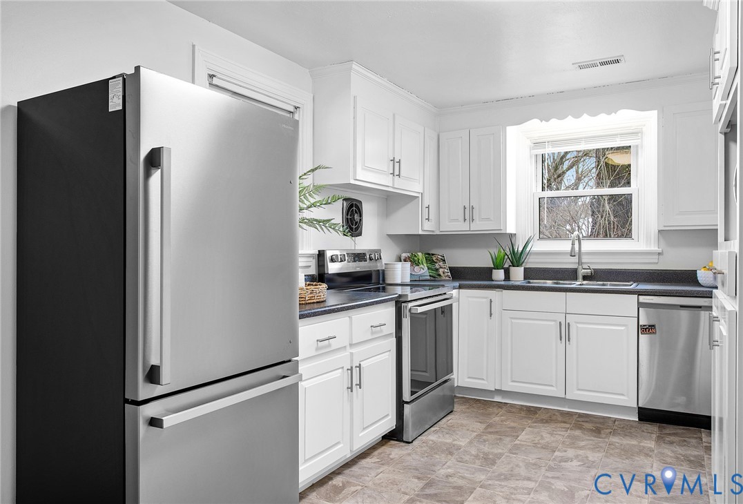 609 Woodstock Road Richmond, VA 23224 - Photo 12 of 33 a kitchen with granite countertop white cabinets and refrigerator