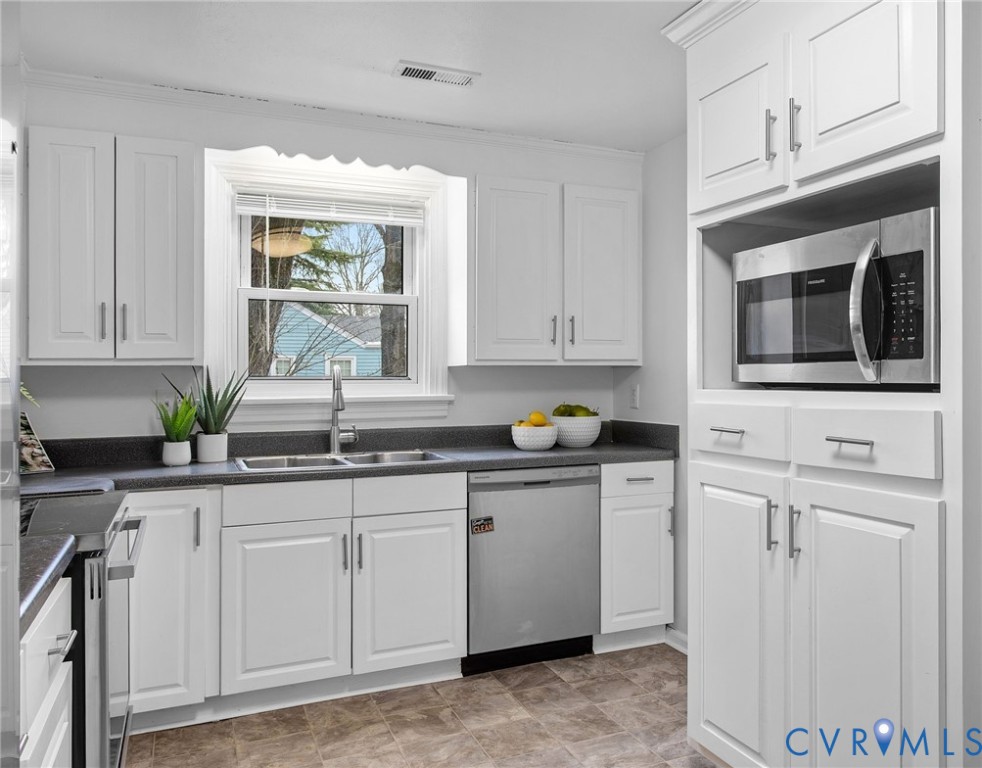 609 Woodstock Road Richmond, VA 23224 - Photo 13 of 33 a kitchen with granite countertop white cabinets white appliances and sink