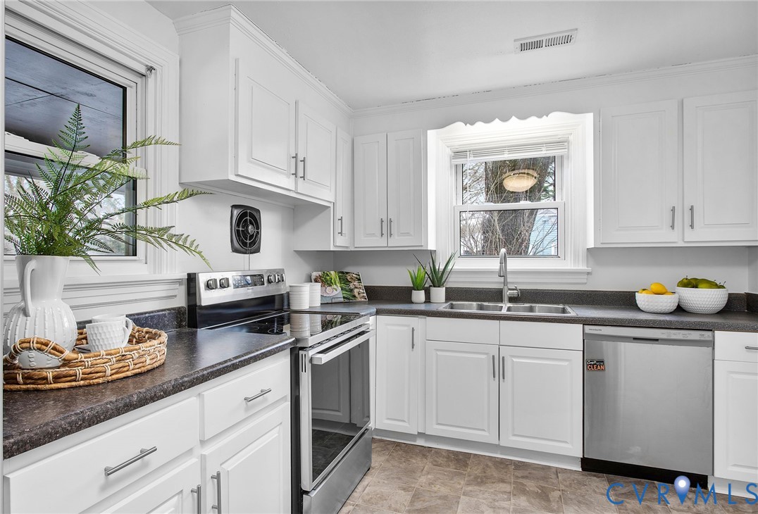 609 Woodstock Road Richmond, VA 23224 - Photo 14 of 33 a kitchen with white cabinets and white appliances