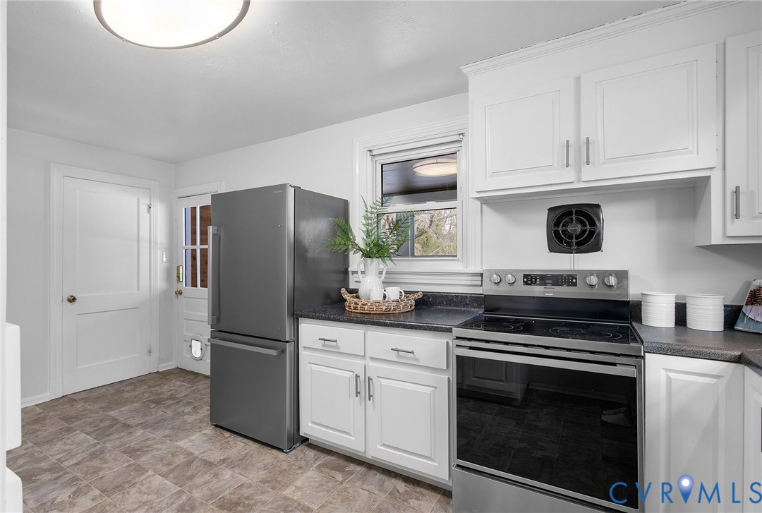 609 Woodstock Road Richmond, VA 23224 - Photo 15 of 33 a kitchen with white cabinets and stainless steel appliances