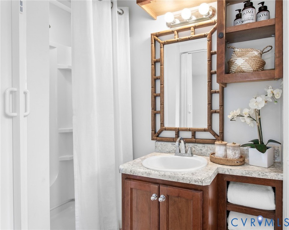 609 Woodstock Road Richmond, VA 23224 - Photo 19 of 33 a bathroom with a granite countertop sink and a mirror