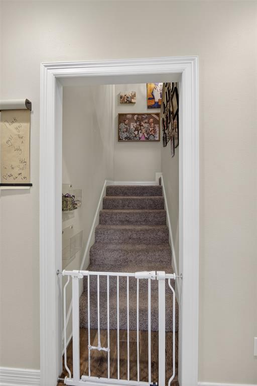 11868 Timber Ridge Drive Keithville, LA 71047 - Photo 28 of 37 Carpeted staircase with white trim, wood-finish flooring at the base, and light-toned walls