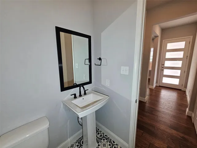 a bathroom with a sink a toilet and a mirror