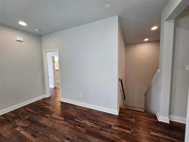an empty room with wooden floor and entrance