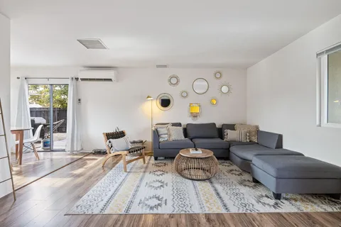 a living room with furniture and wooden floor
