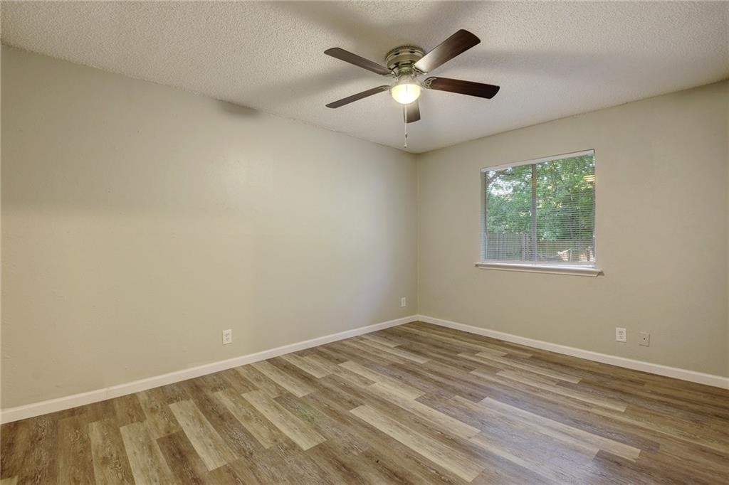 2311 Teri Road, Unit B Austin, TX 78744 - Photo 16 of 25 an empty room with wooden floor and windows