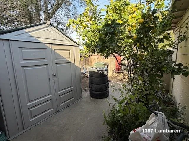 a view of a patio with table and chairs potted plants and large tree