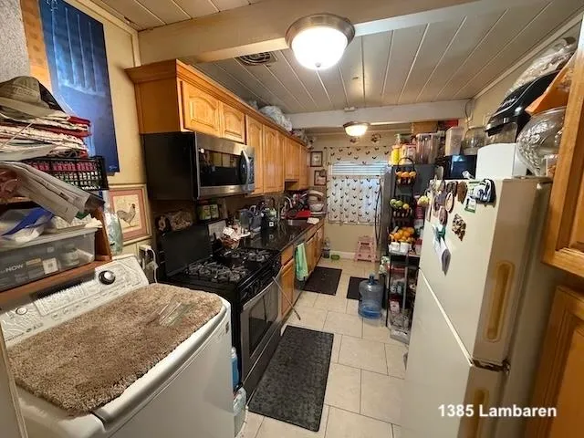 a view of a kitchen with fridge and workspace